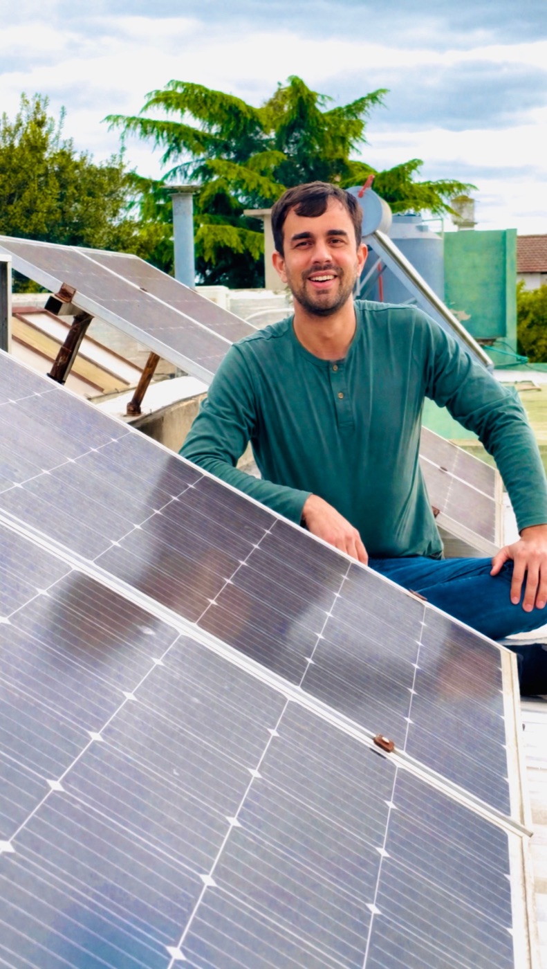 Nicolás Vescovo sonriendo junto a paneles solares en una terraza de Pehuajó